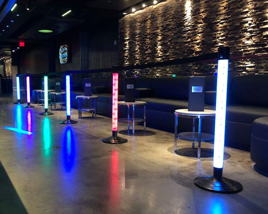 Modern lounge area with Event LED Stanchions and dark upholstered seating.