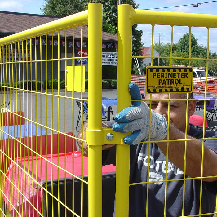 Workers assembling Perimeter Patrol portable fencing with clamps and base plates